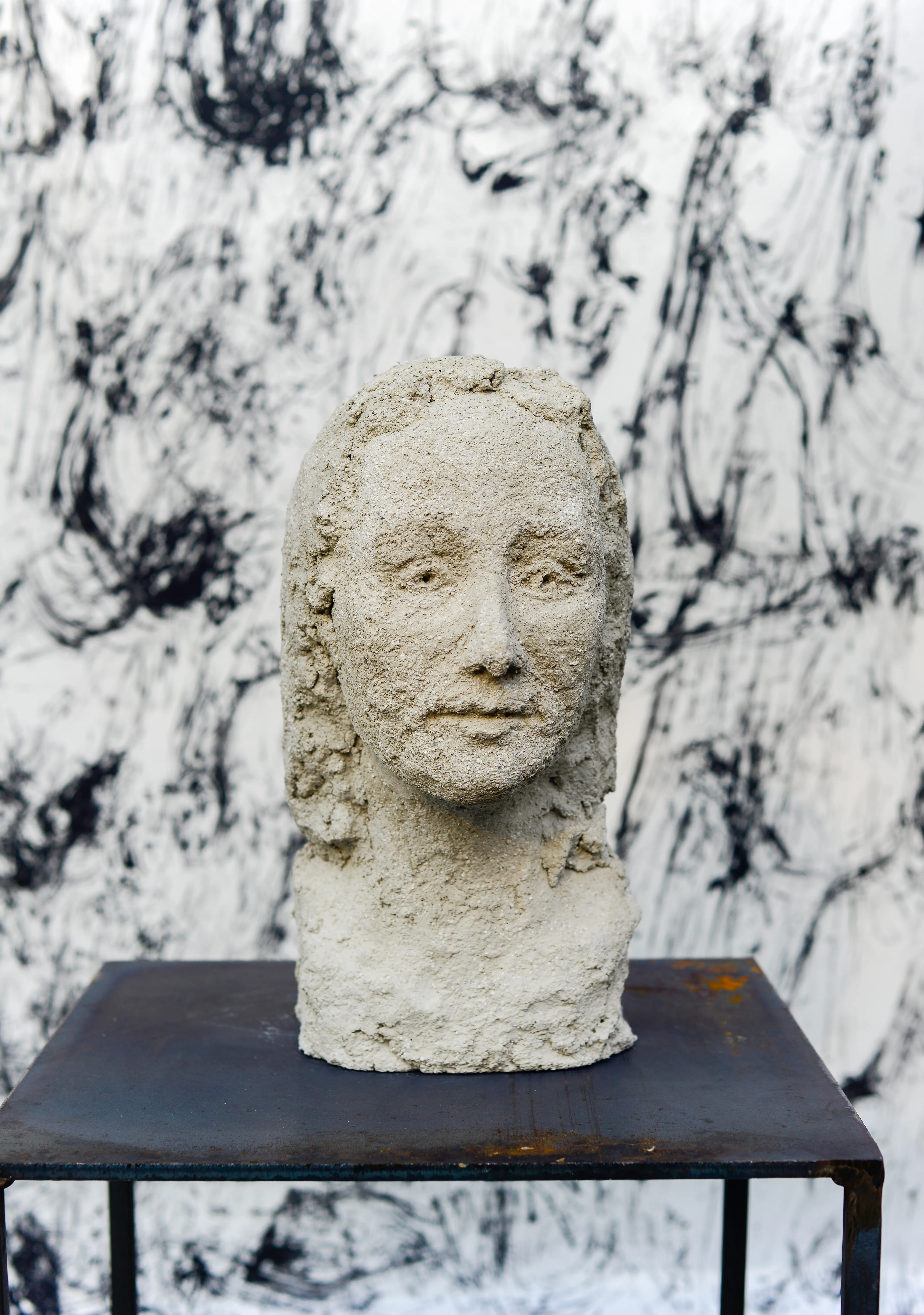 Foto, welches eine Skulptur eines Frauenkopfes zeigt, vor einem schwarz-weißem Hintergrund