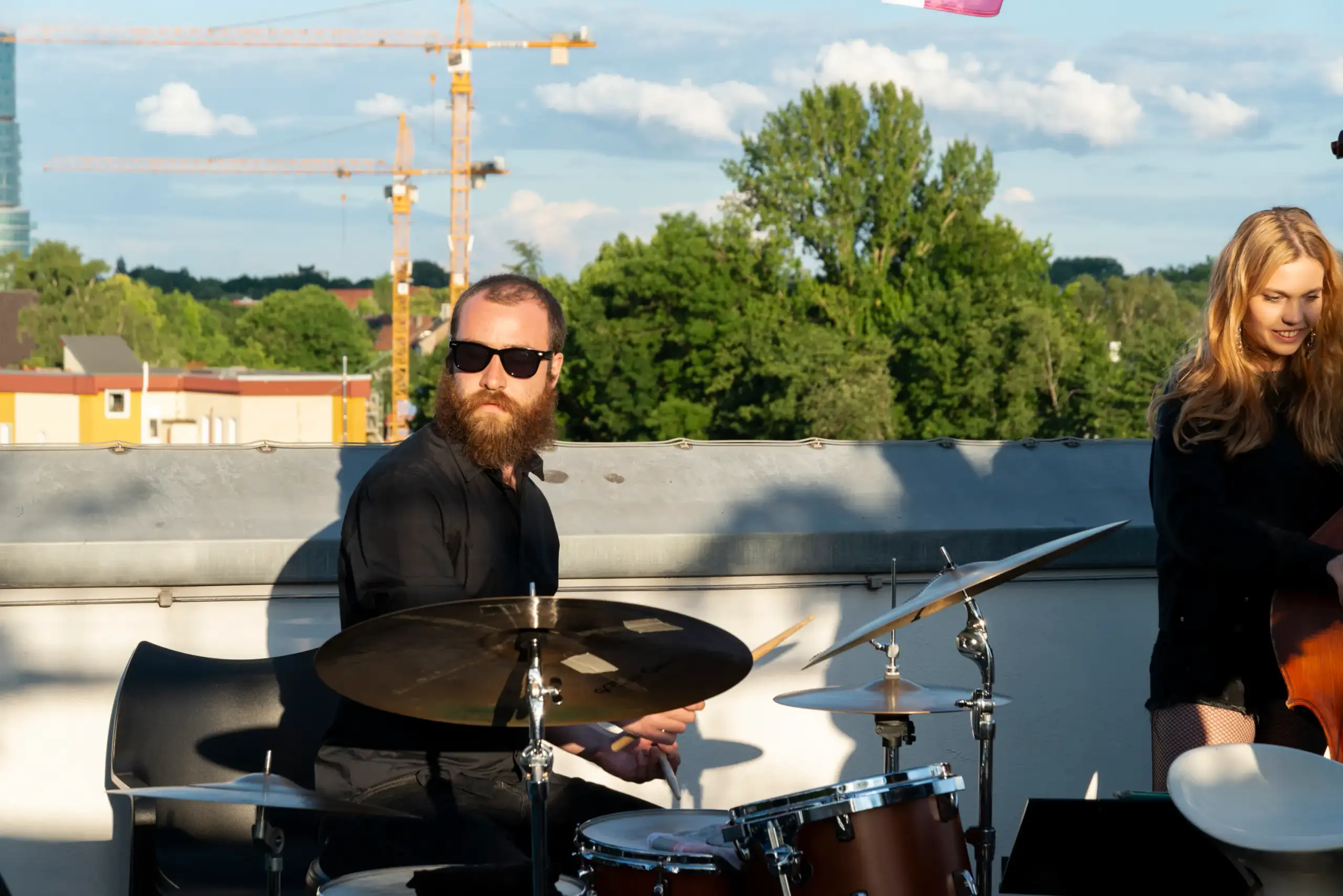 Foto eines Schlagzeugspielers auf dem Dach eines Hochhauses